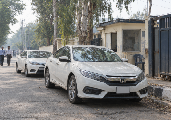 Guarded Compound Entrance with White Sedans