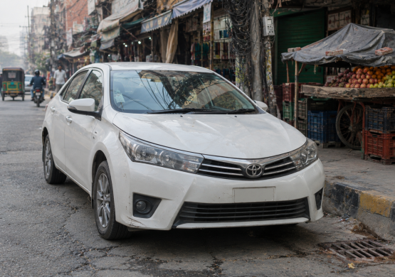 White Toyota Sedan at a Gritty Market Street